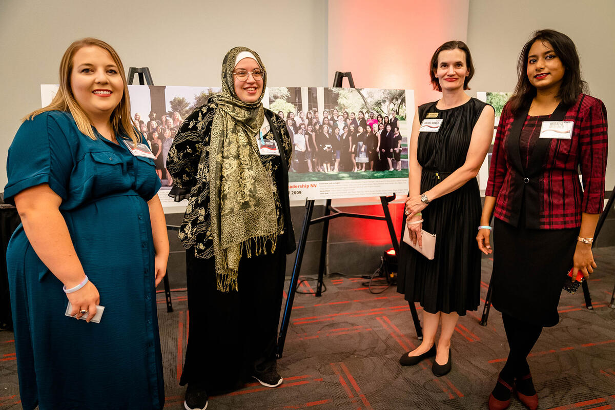 Four women standing in front of a presentation board