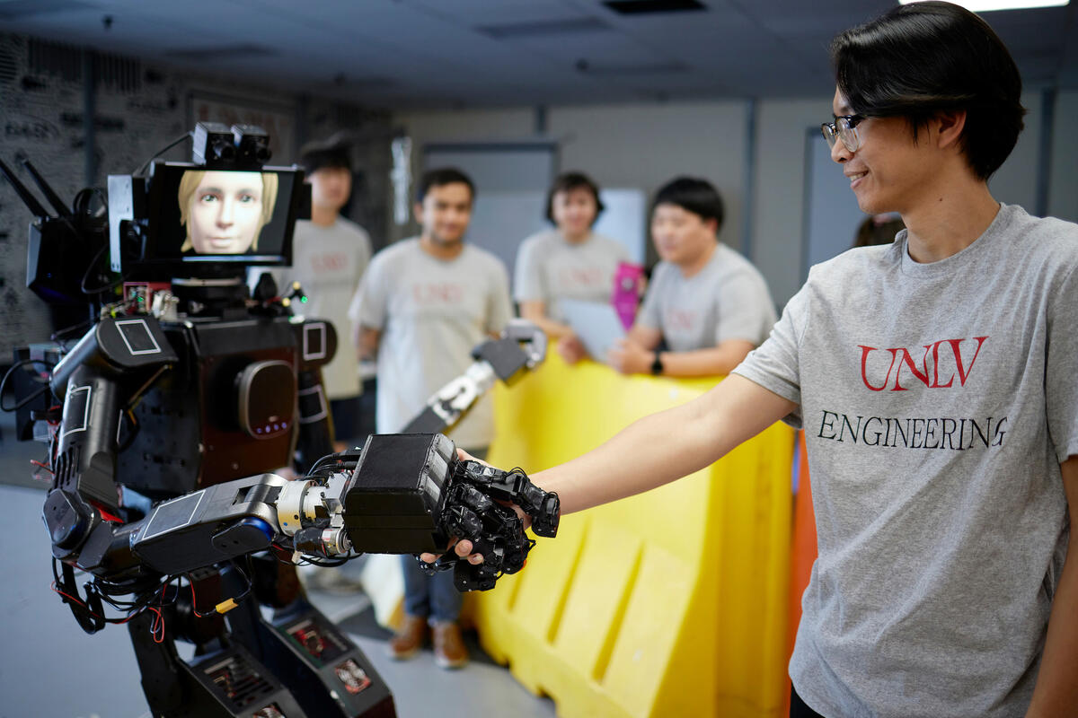 student interacting with humanoid robot