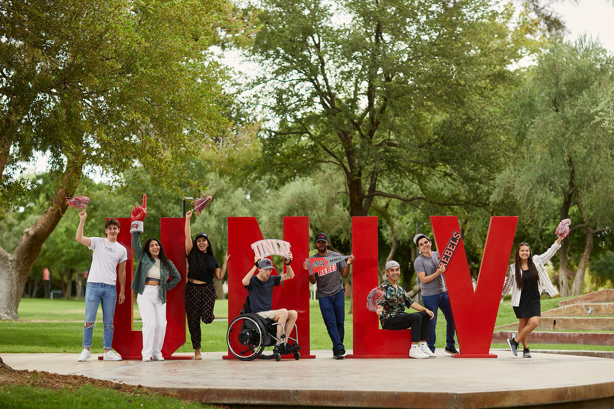 Students standing in front of an U-N-L-V sign