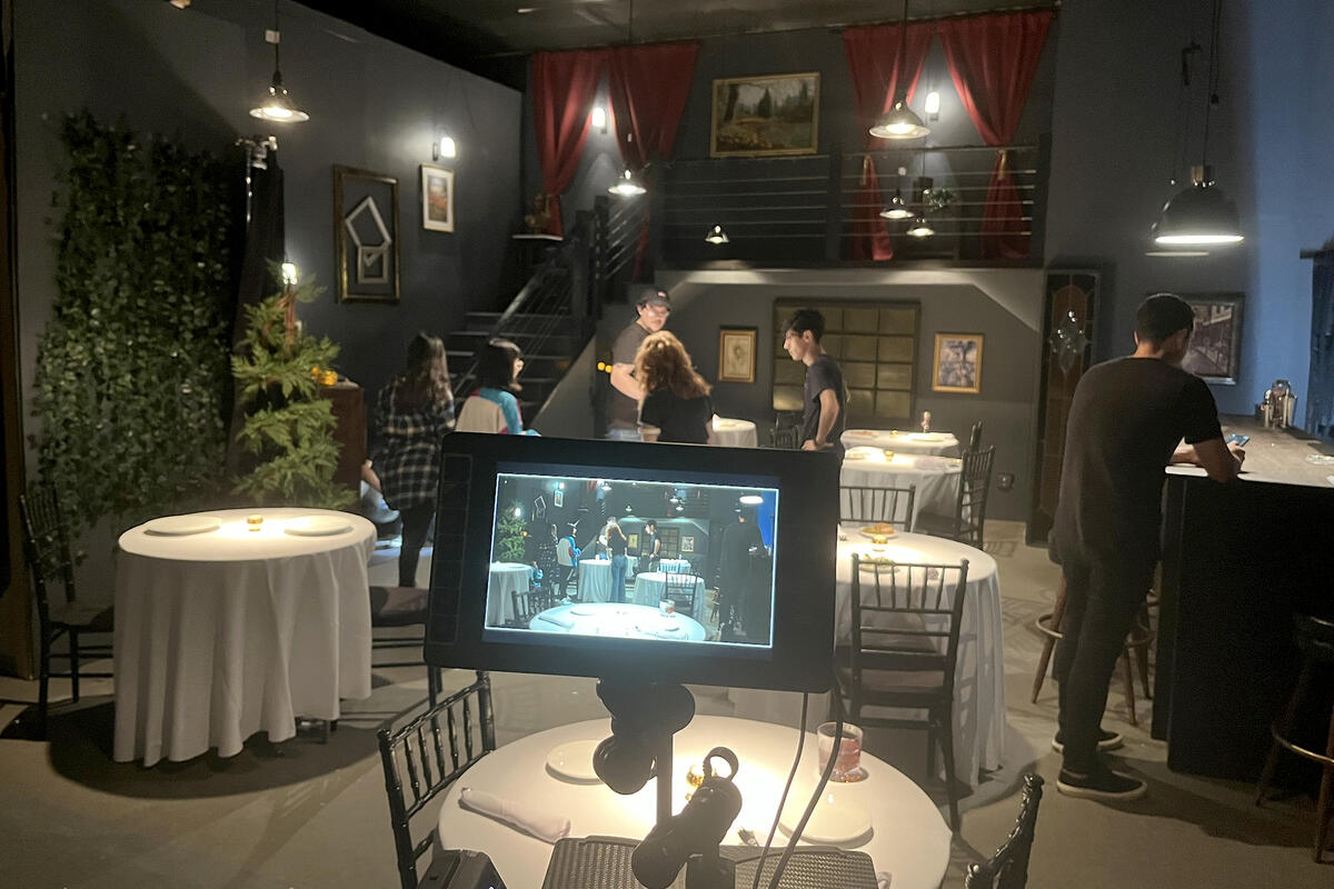 on a film set with camera monitor in foreground showing restaurant scene