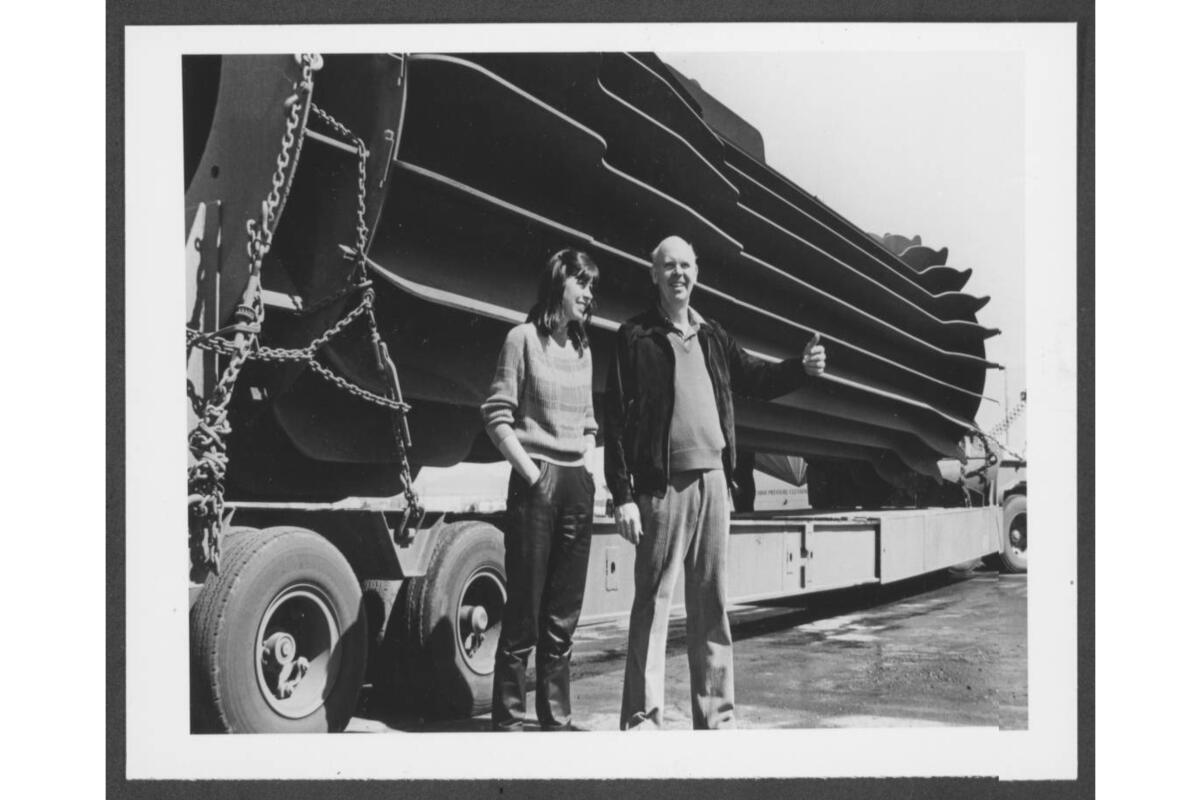old photograph of a couple in front of a large flashlight sculpture
