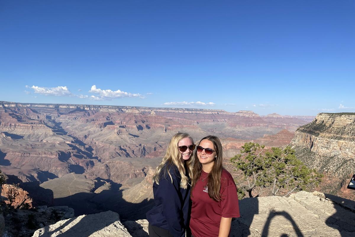 two college students posing in front of desert landscape