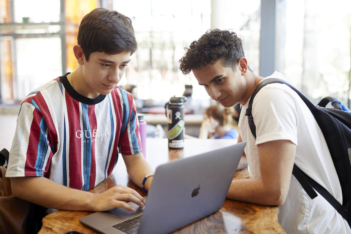 two male students looking at laptop