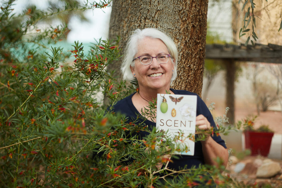 woman hidden behind bush holds book