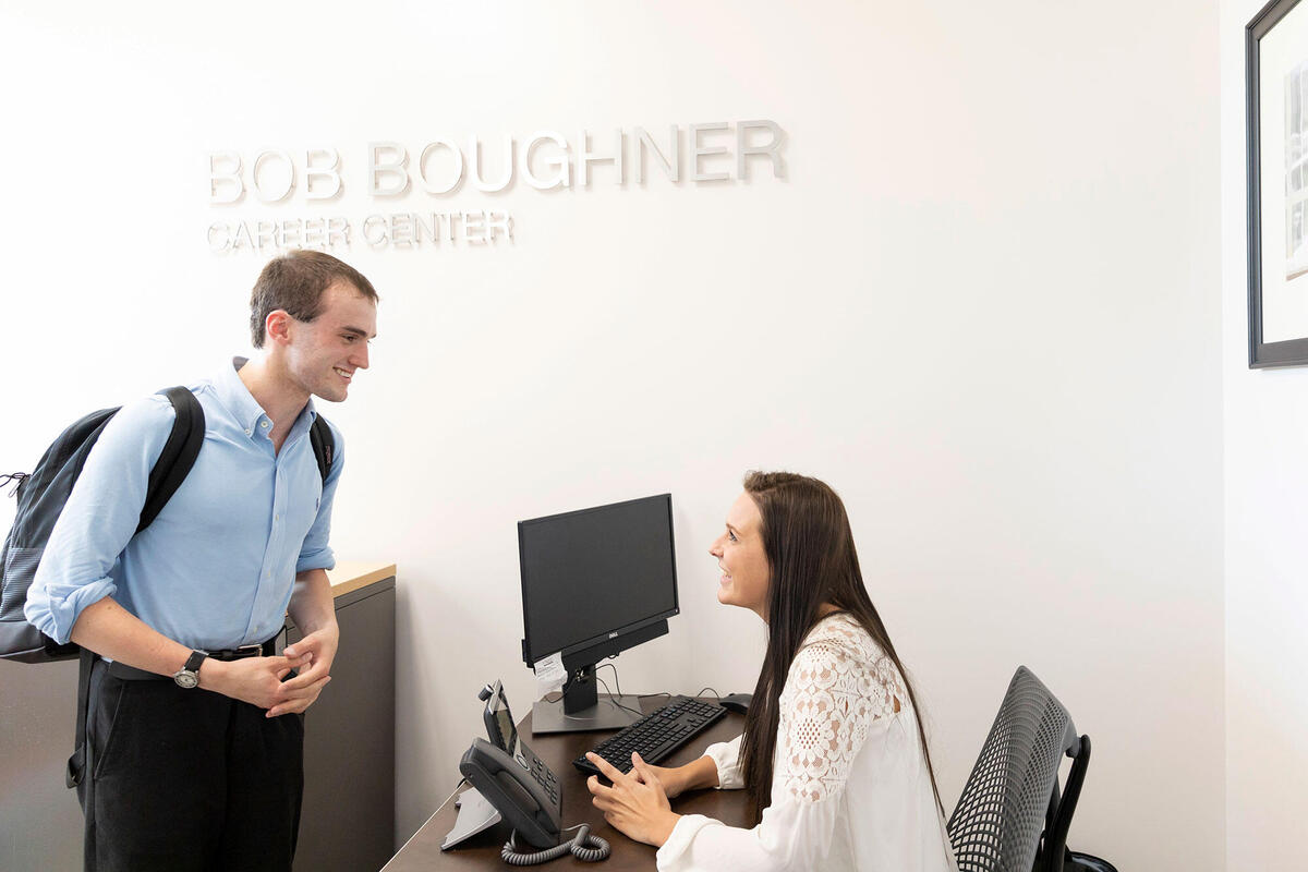 student talking to faculty in hospitality building