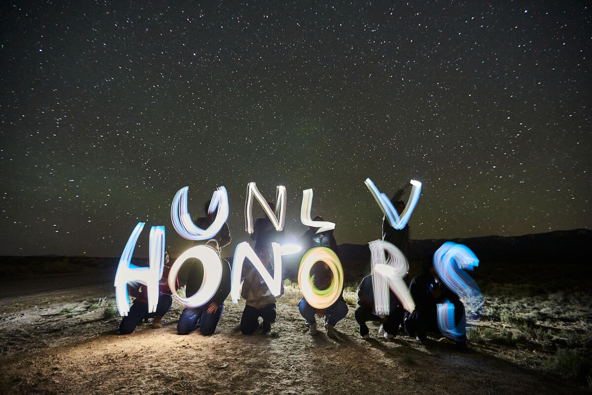 A group of people outside spelt out UNLV Honors using lights