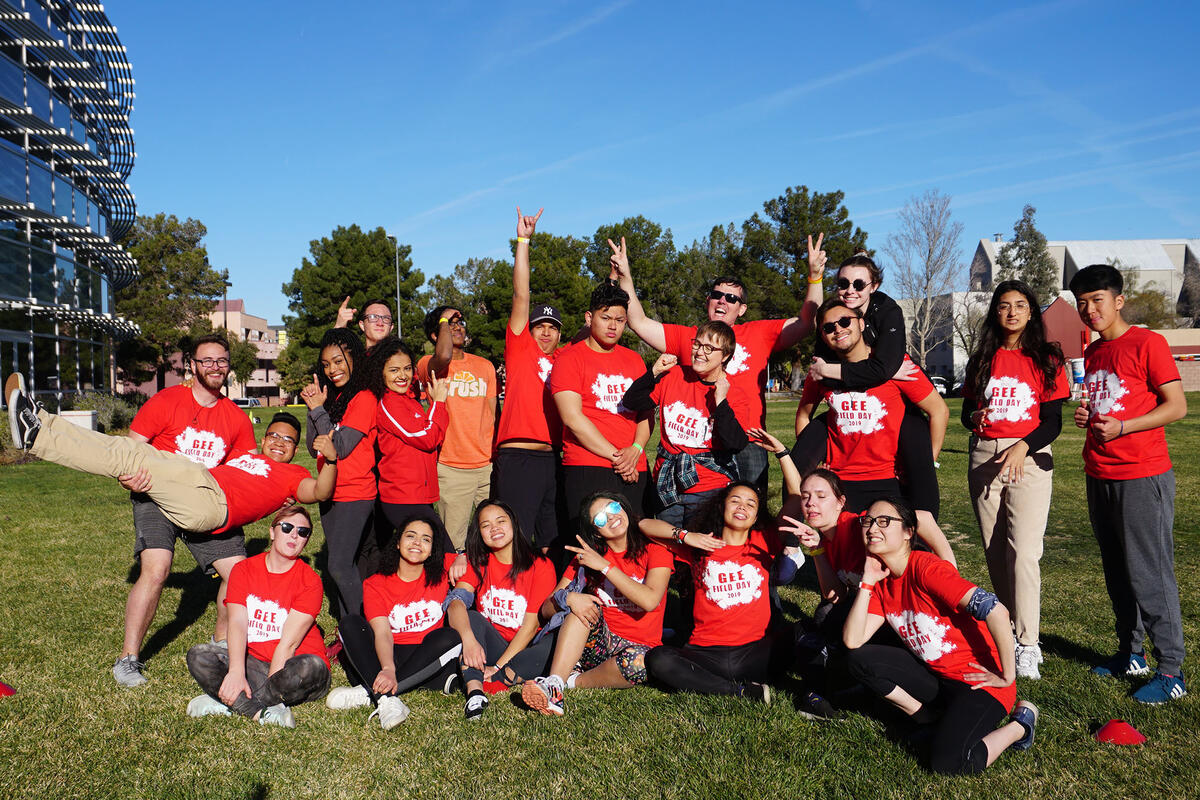 Group of people posing at camera while wearing red shirts