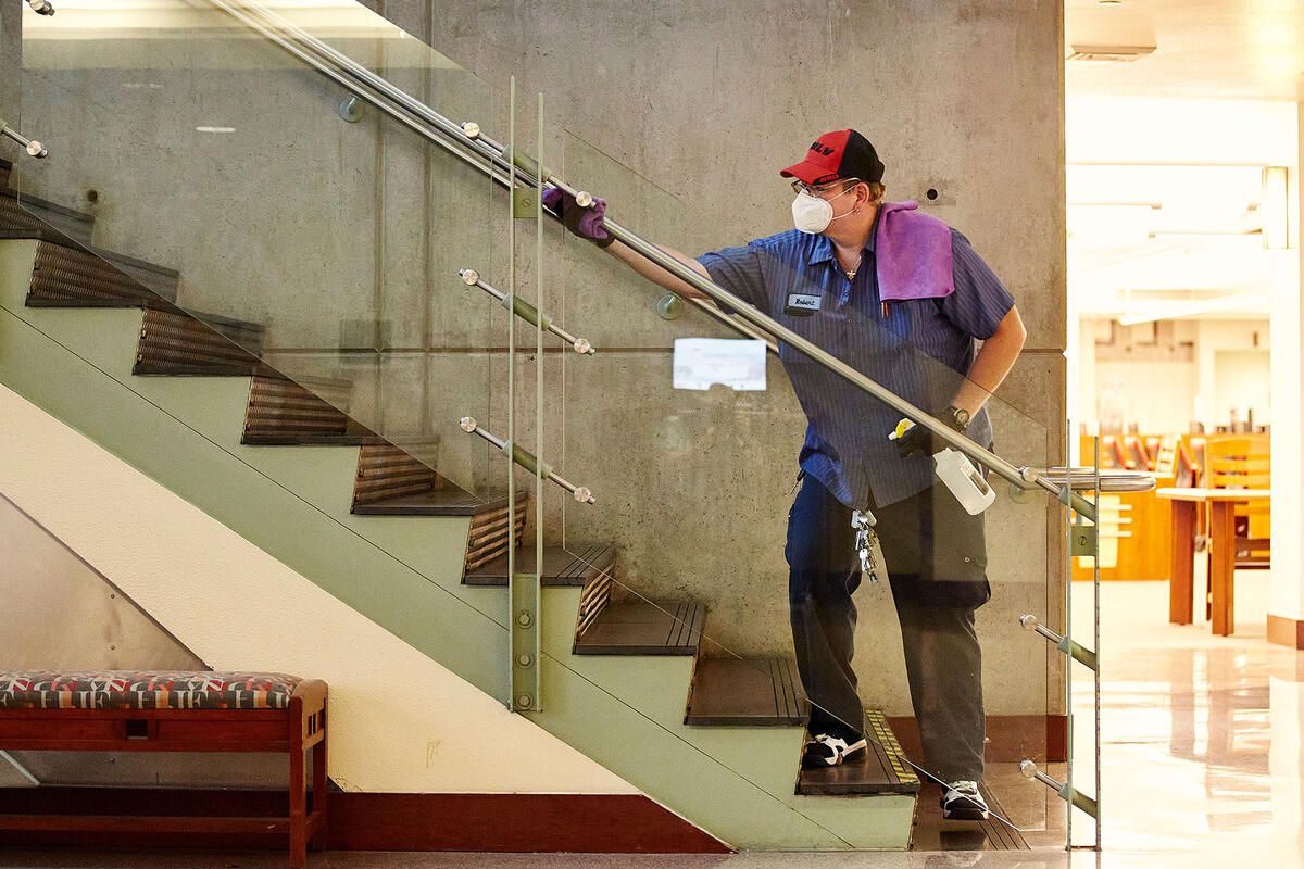 man cleaning the glass of a stairs