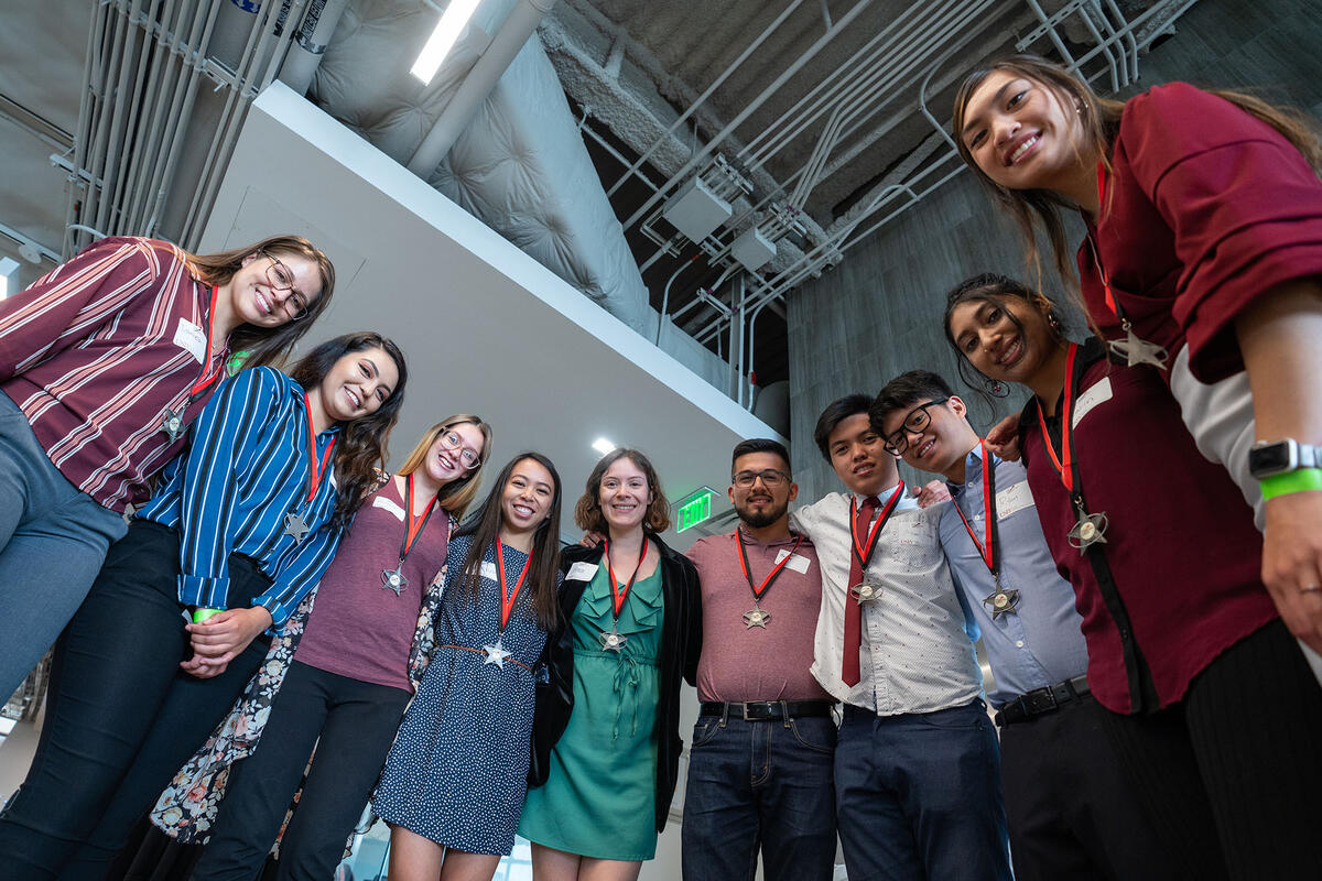 Group of people smiling down at a camera