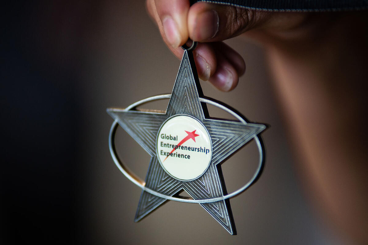 Person holding star medallion that says "Global Scholarship Entrepreneurship" 