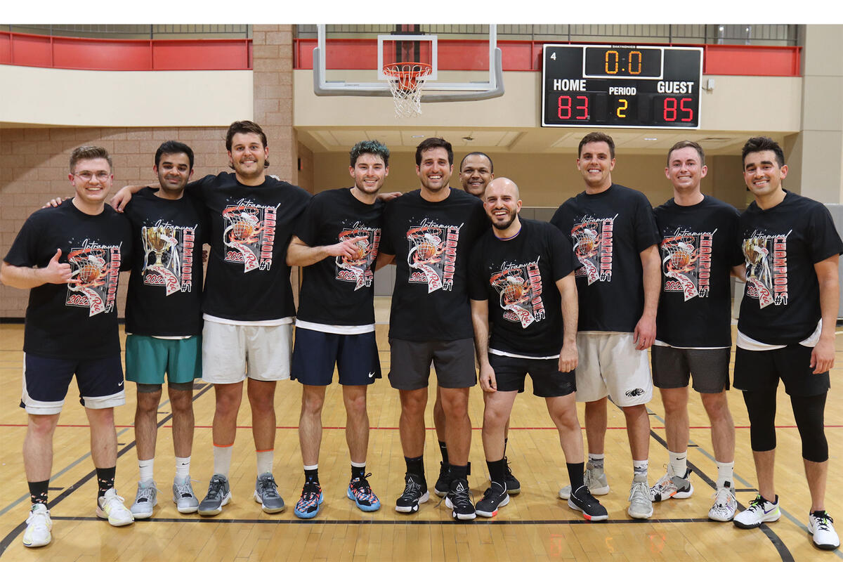 10 men standing together for a group photo on a basketball court