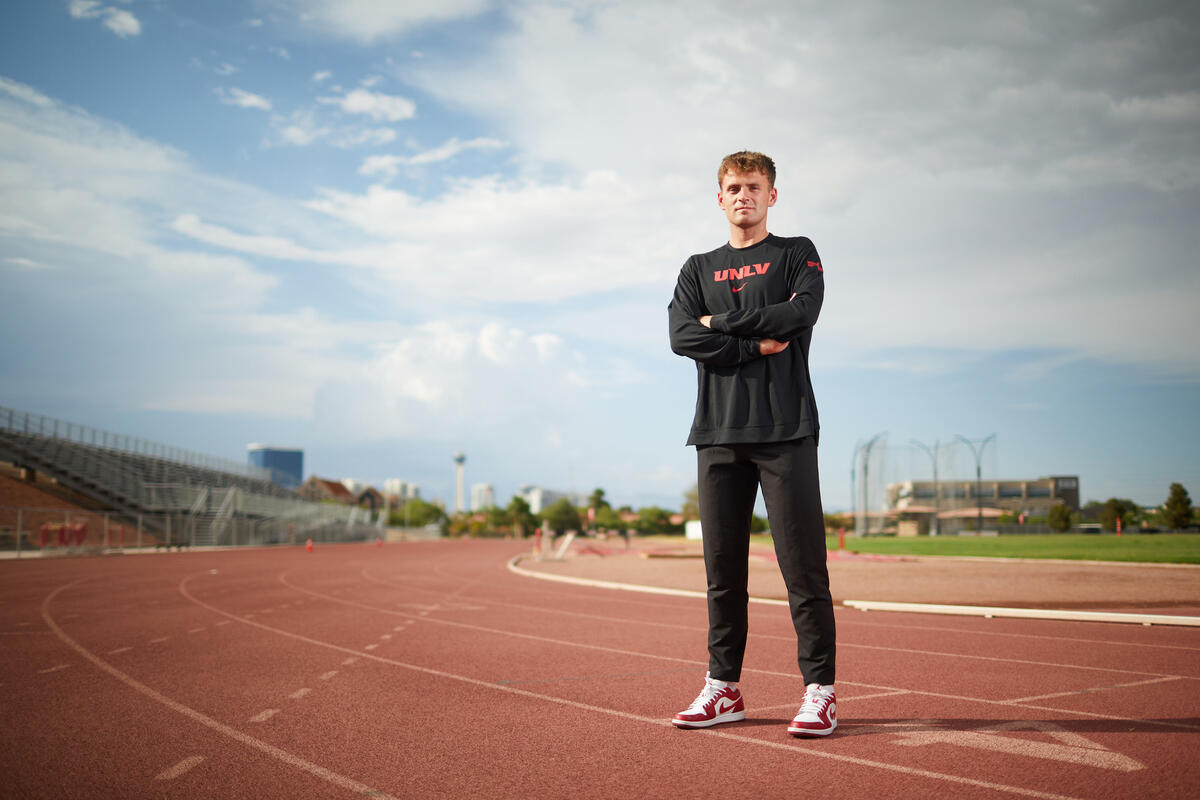 young man in black clothes posing on running track