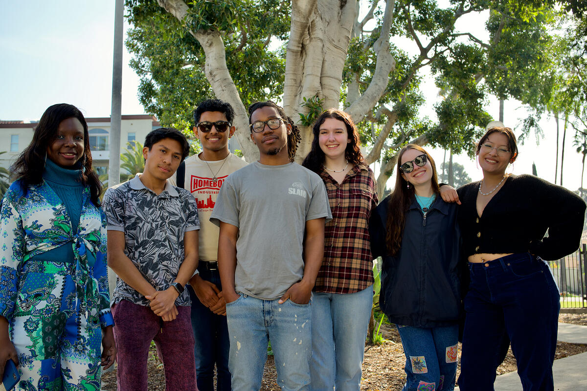 group of students outdoors with a tree behind