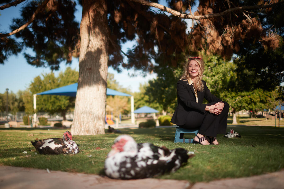 woman under tree poses by birds