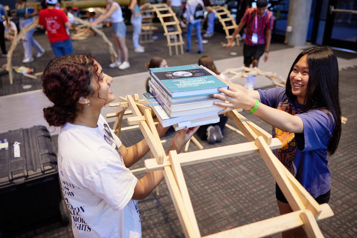 two students building a book tower