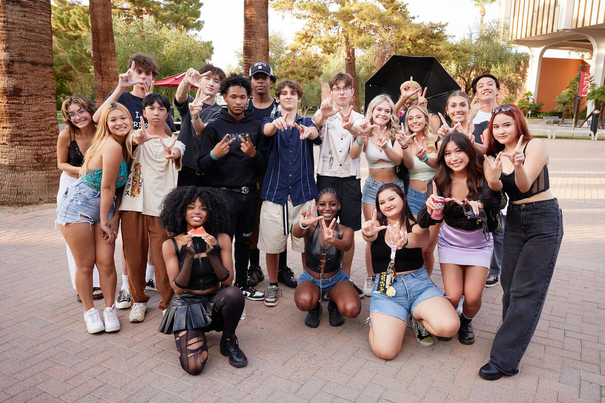 group of students posing for a photo while showing LV hand signs