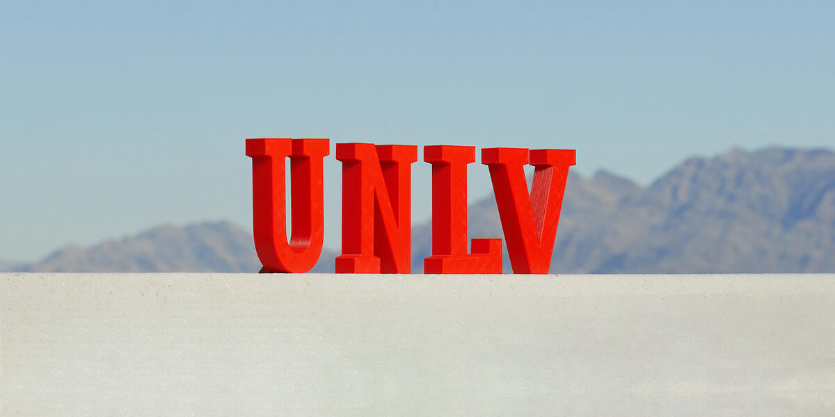 UNLV Letters on a ledge with mountains behind
