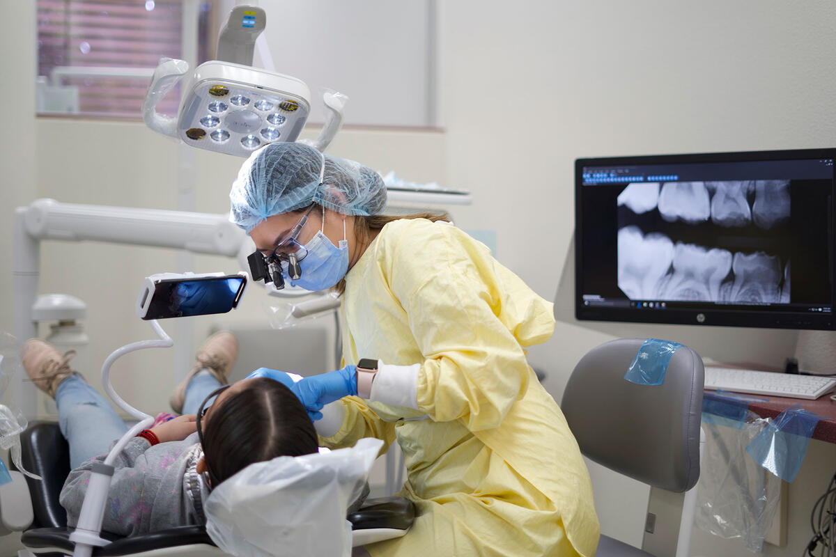 A hygienist looking at a patient's teeth