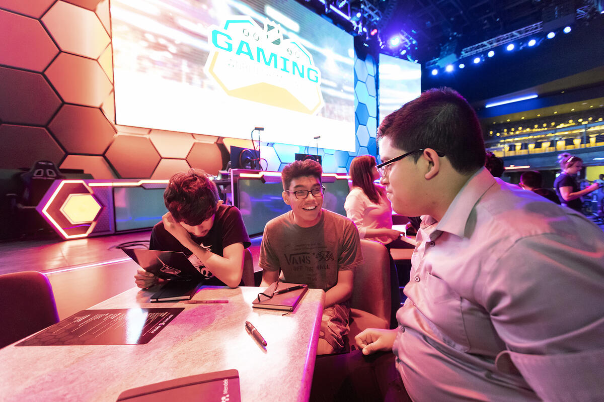 People sitting at a table next to a glass high tech wall