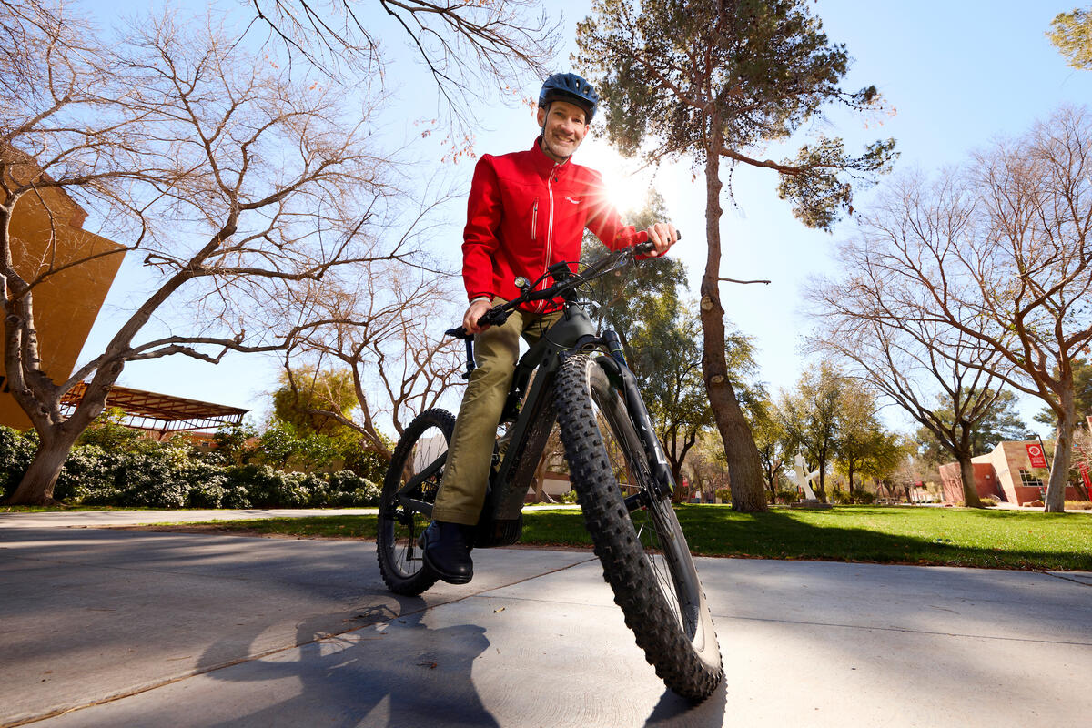 man sits atop bike in park