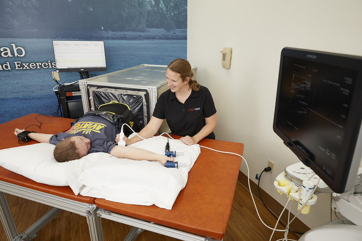 A person conducts a scan on another person laying on a table