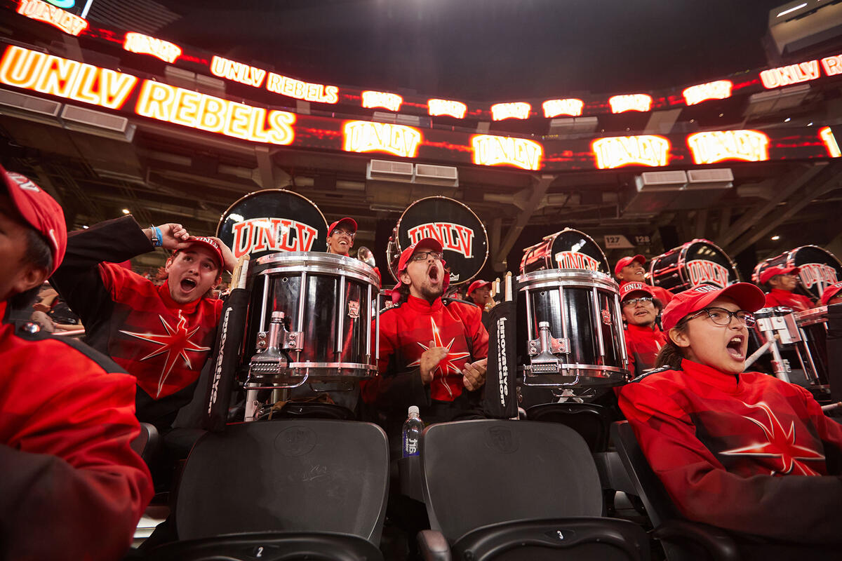 A group of band members cheering and playing on the drums