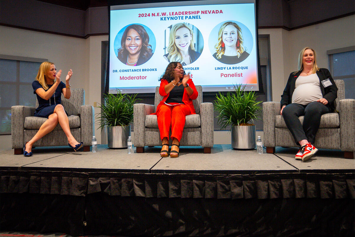 Three women panelists speaking on stage