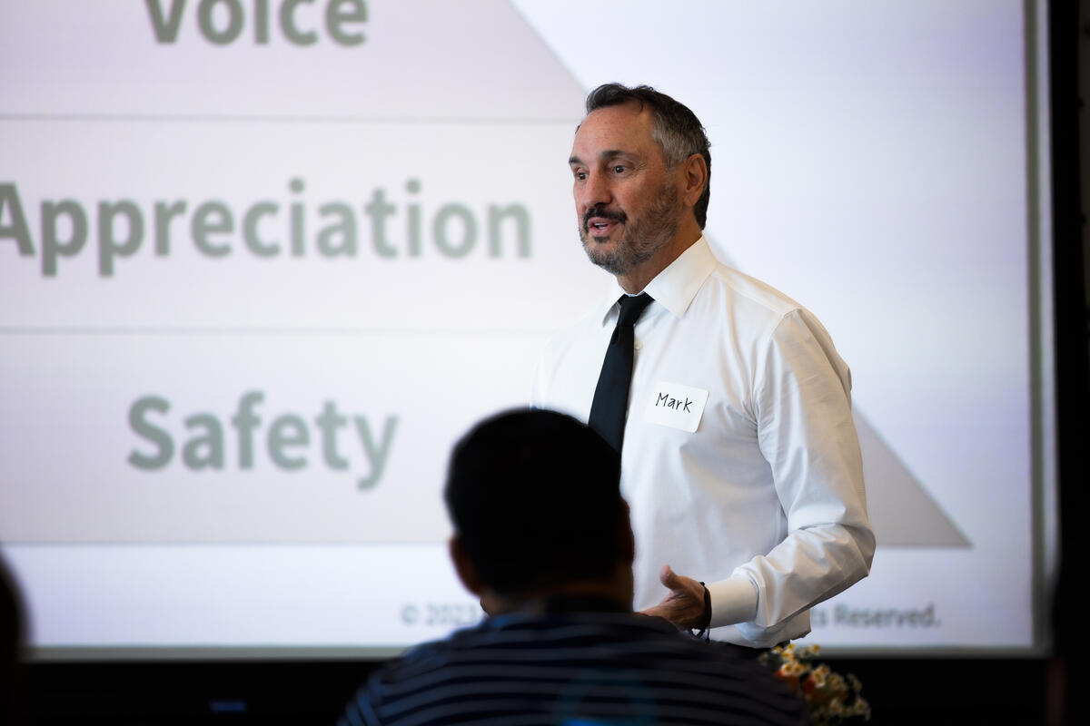A person wearing white and giving a presentation