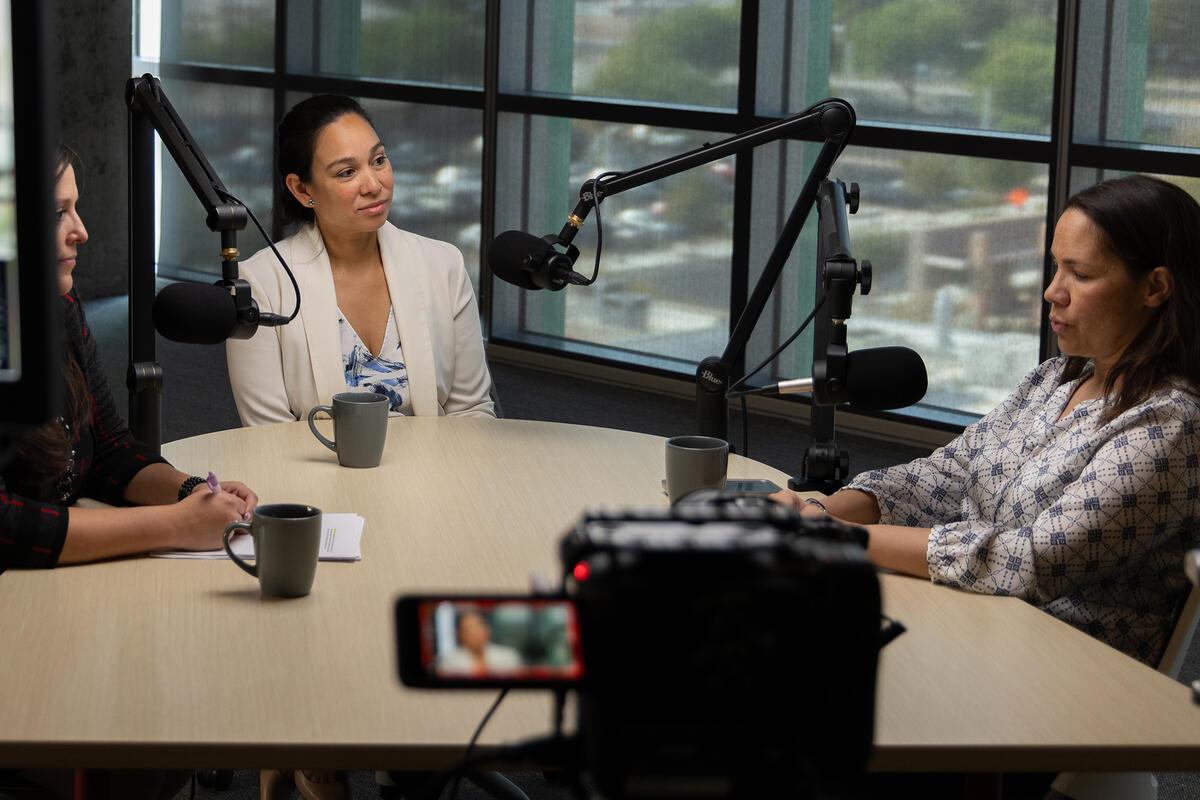 Three faculty members sitting around a table for a video interview.