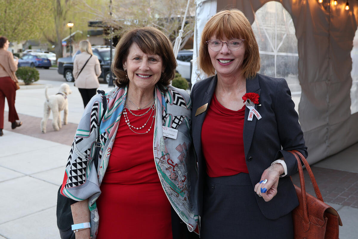 Two people smiling for the camera wearing UNLV STRONG ribbons
