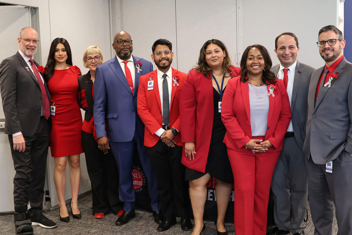 A group of nine people in business attire standing in a row