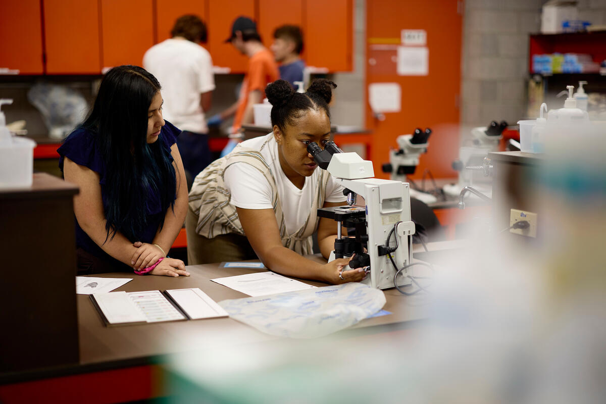 Raizel Yankaway looking into a microscope in lab