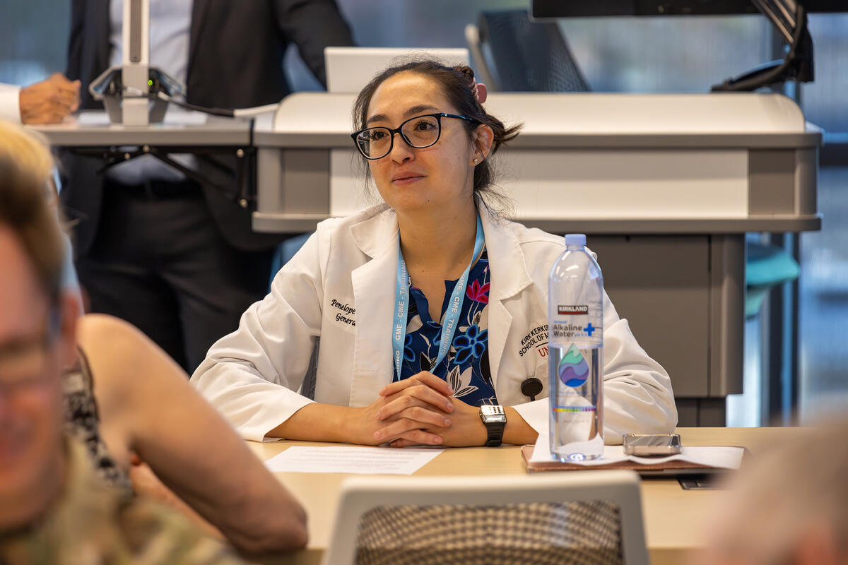 Medical student having a conversation with someone at a table.