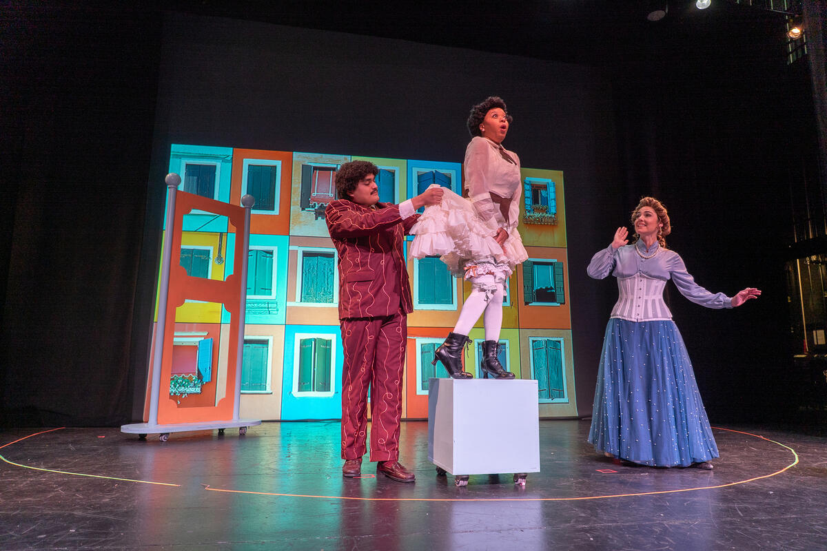 three actors from the underpants on stage in costume