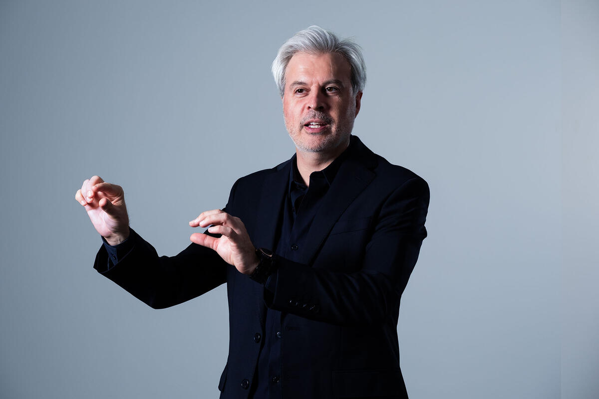 portrait of man holding his arms as a music conductor does