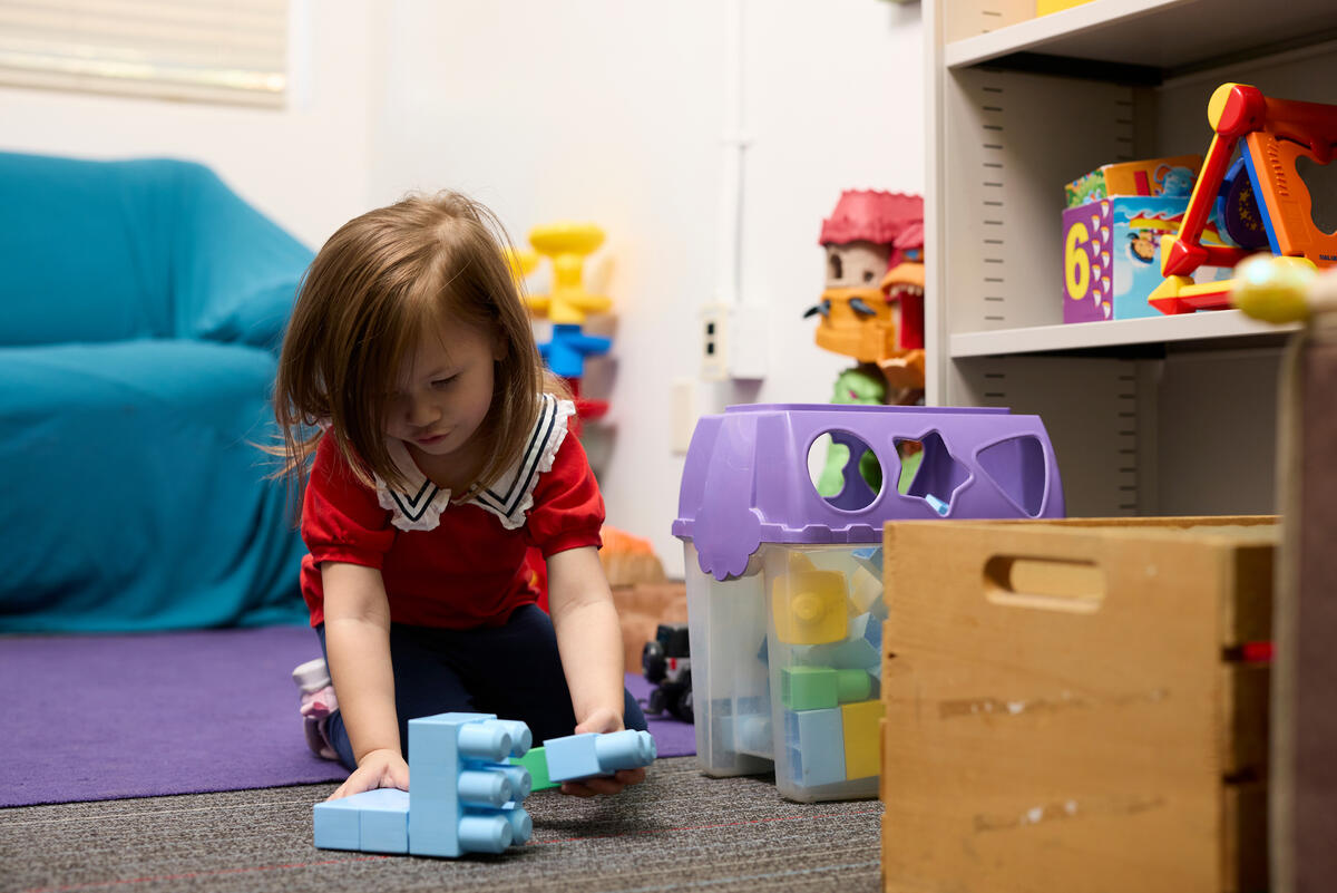 young girl plays with toys in living room setting