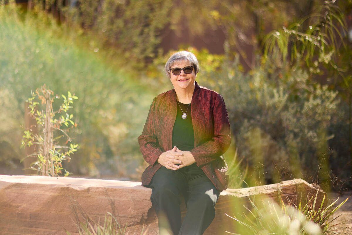 Anni Drury sits on stone wall on UNLV campus