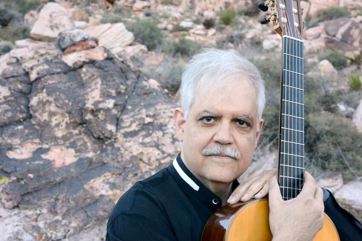 man posing with guitar in outdoor setting