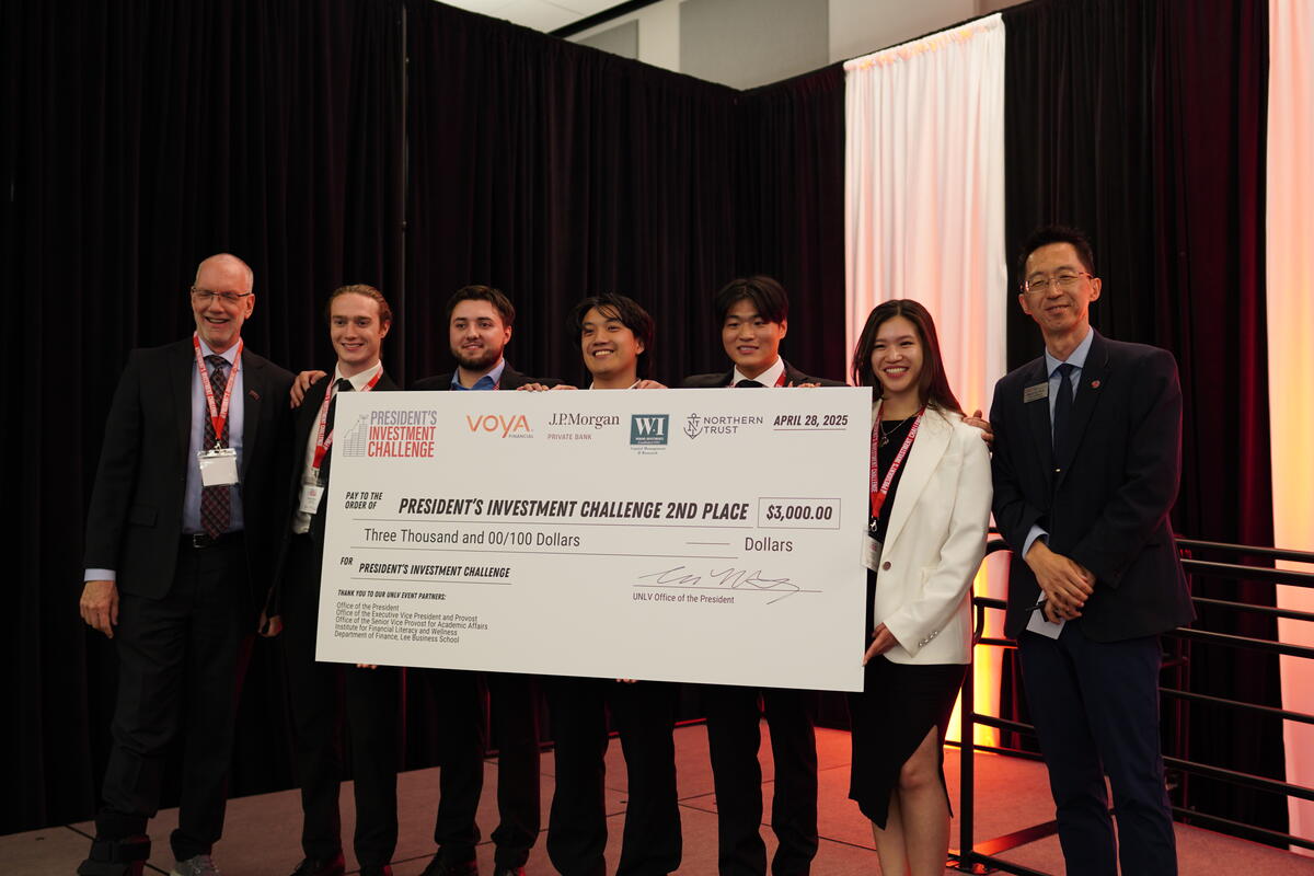 7 people holding a large check for 2nd place of the President's Investment Challenge