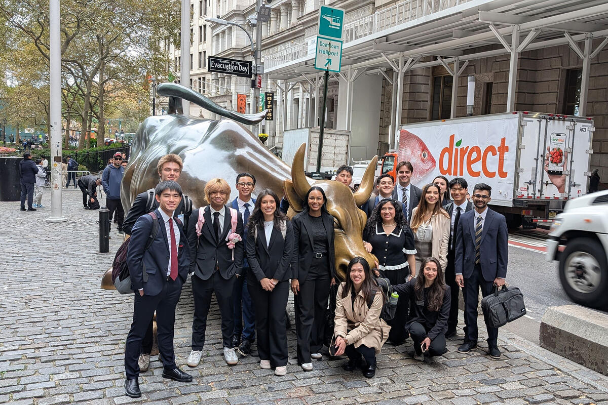 A group of students gathers in front of the Charging Bull statue in New York’s Financial District.