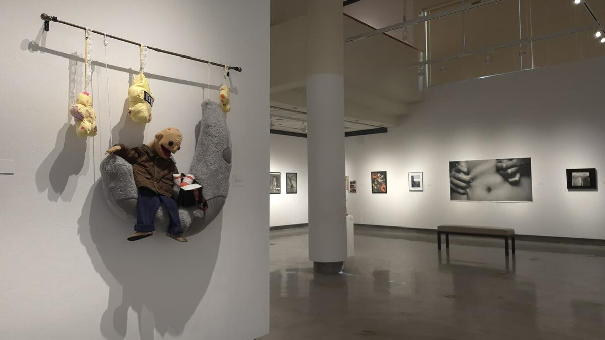 A wall with a curtain rod attached with a puppet sitting on a plush moon and plush stars