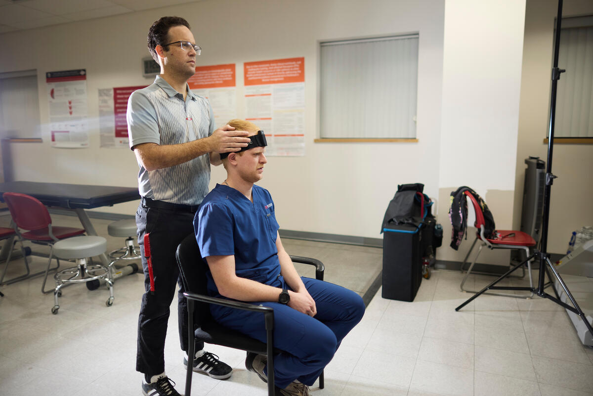 Physical therapist diagnosing concussion symptoms in patient
