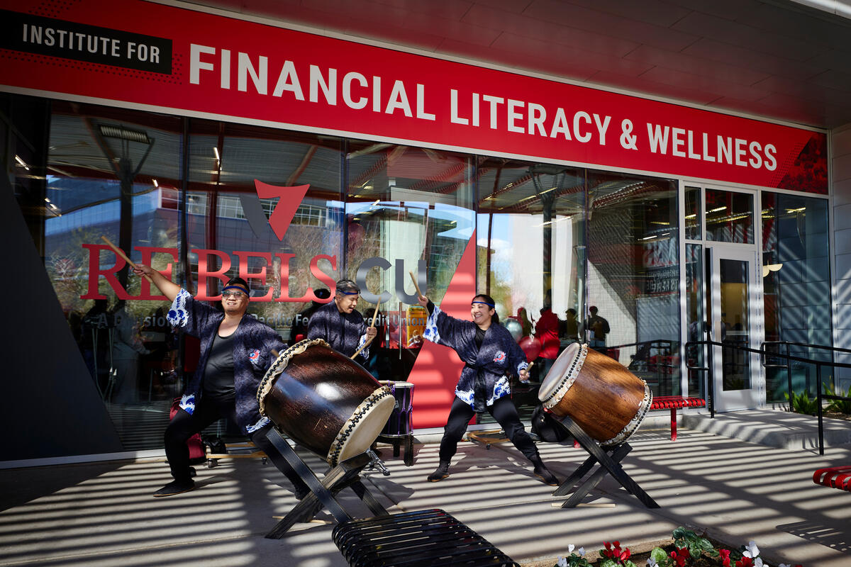 individuals playing taiko drums in front of literacy wellness institute