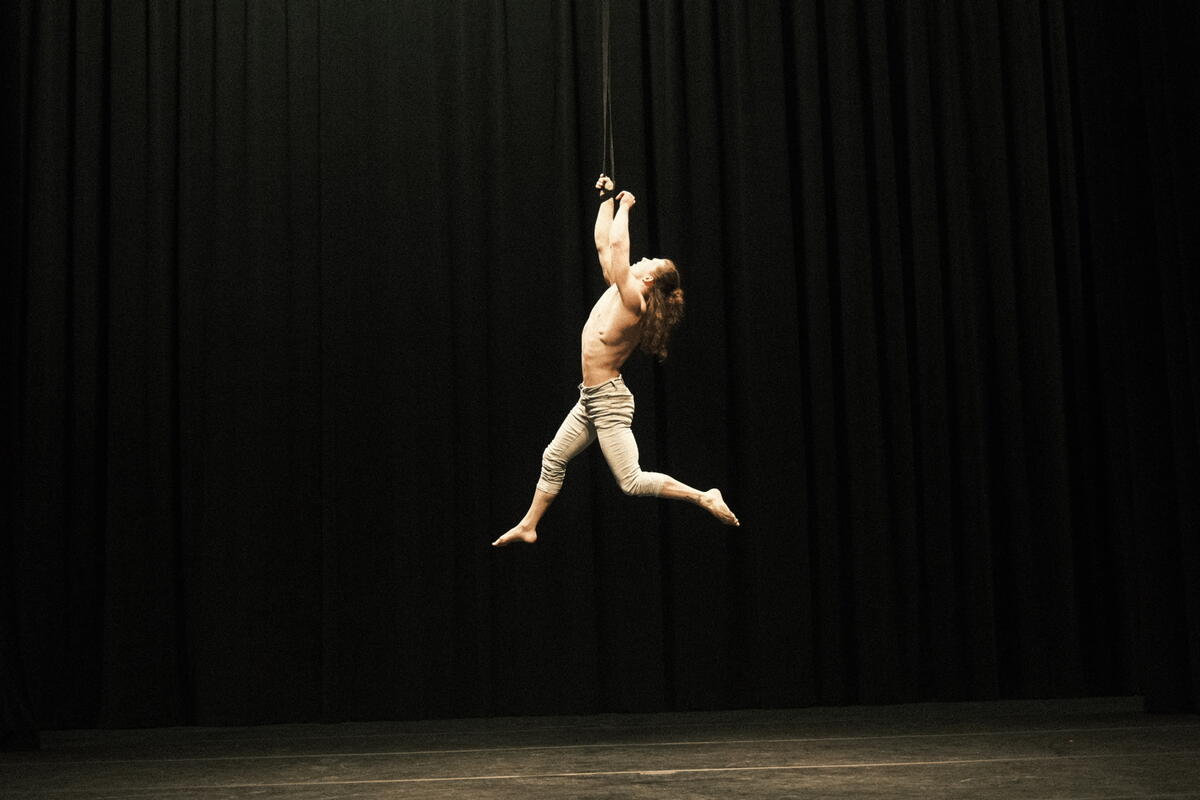 acrobat hanging from ceiling