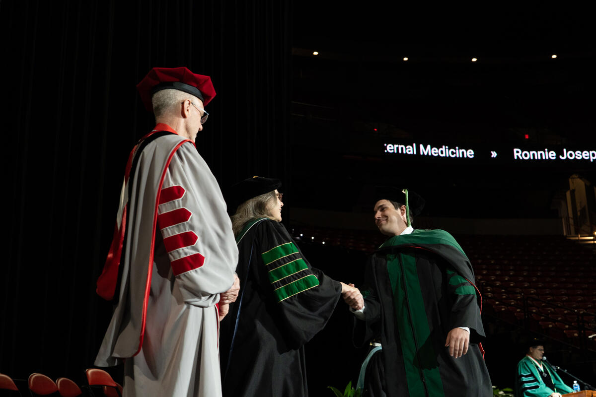 Kirk Kerkorian School of Medicine at UNLV Class of 2026 student shaking Dean Netski's hand at the commencement and academic hooding ceremony