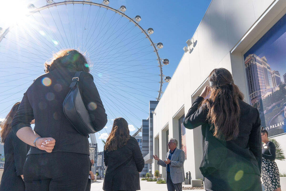 A group of people standing outside of the High Roller on the Las Vegas strip