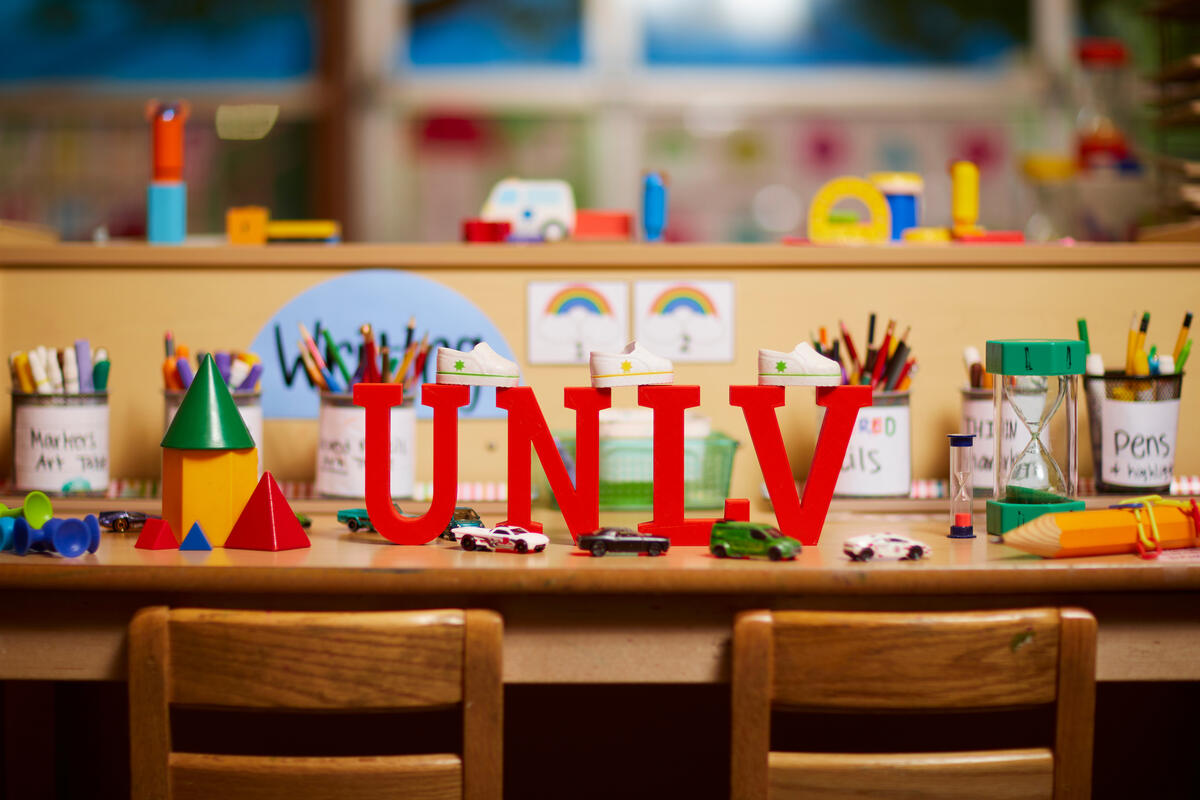 UNLV miniature letters set on a school desk with toys and school supplies.