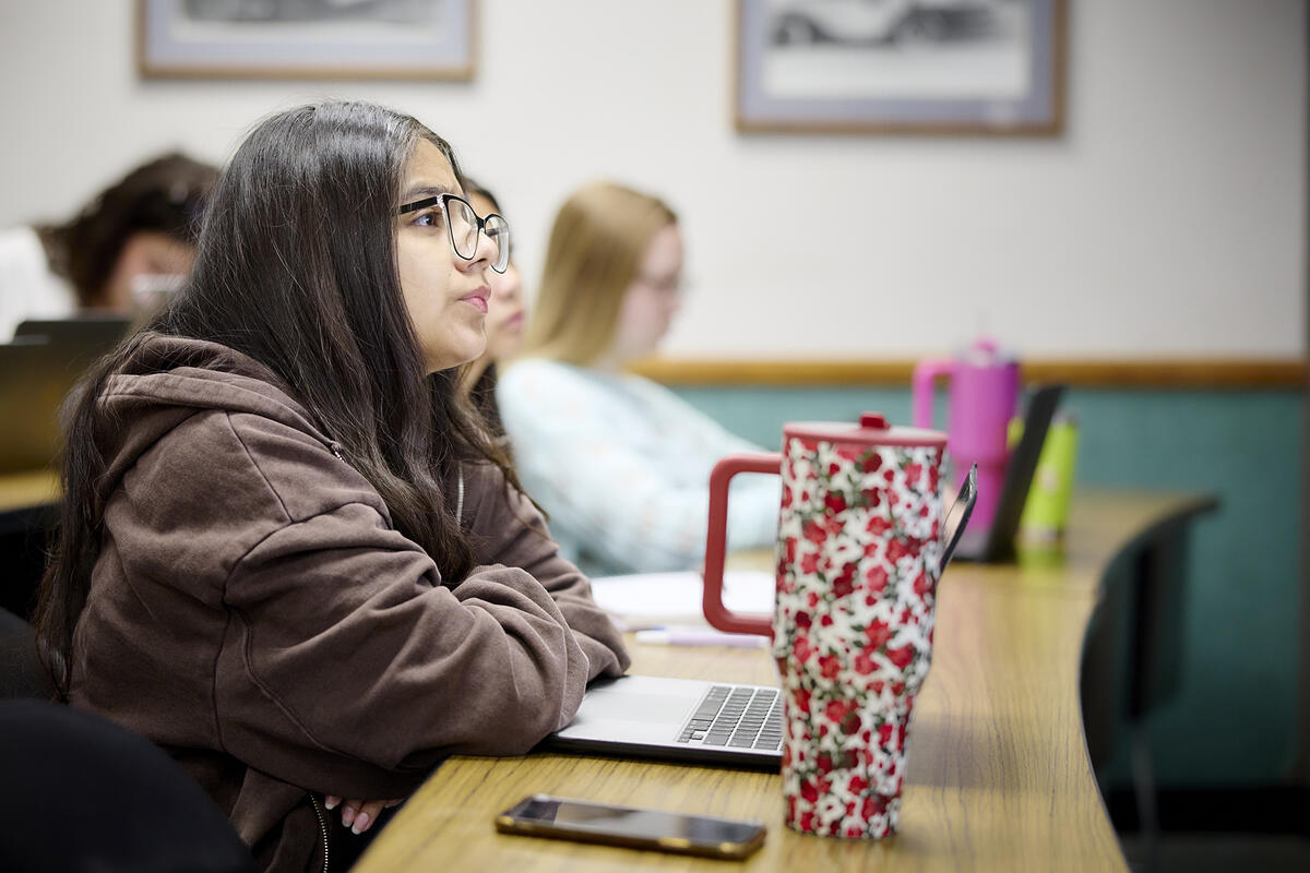 A student sitting down in a classroom