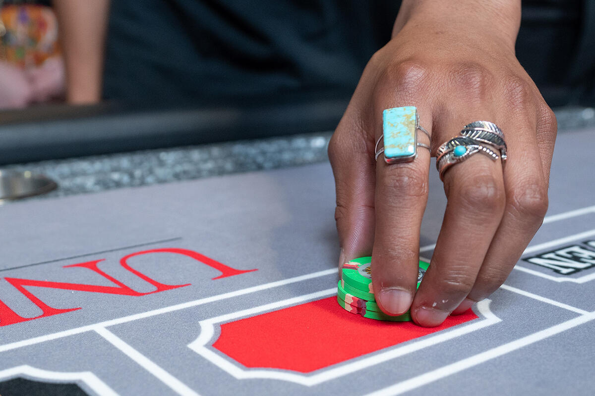 A man holding a pile of poker chips on a table