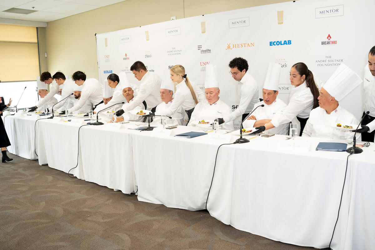 A row of chef judges doing a taste test.